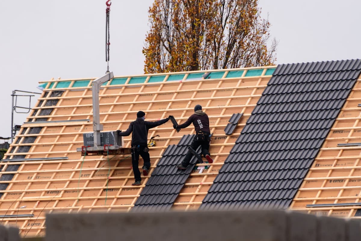 Handwerker bei der Neueindeckung eines Daches